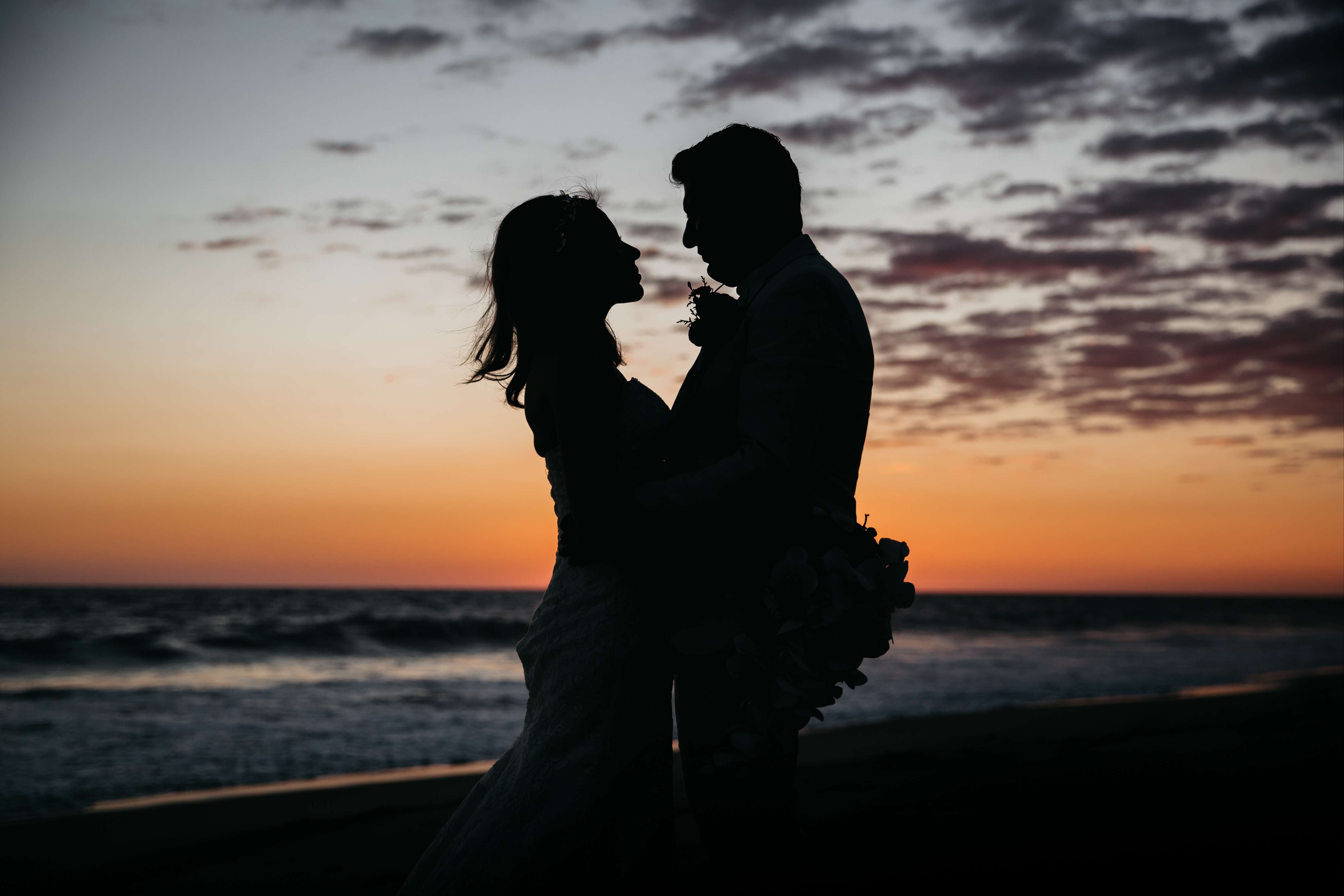Novios, disfrutando el atardecer en la playa